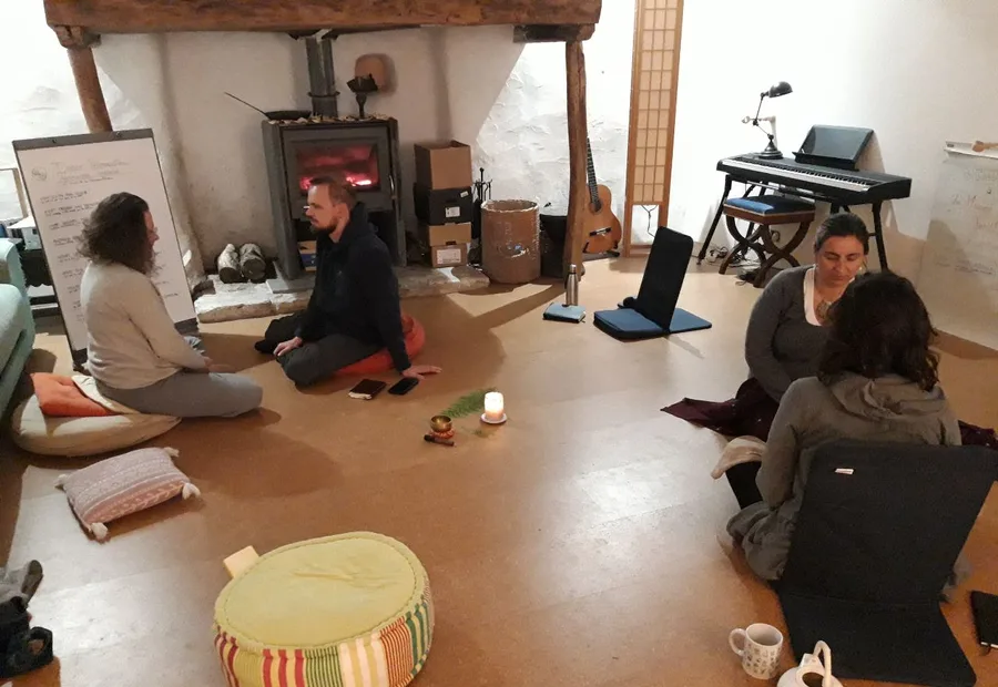 Un cercle de parole autour du poêle, cinq personnes assises sur des coussins