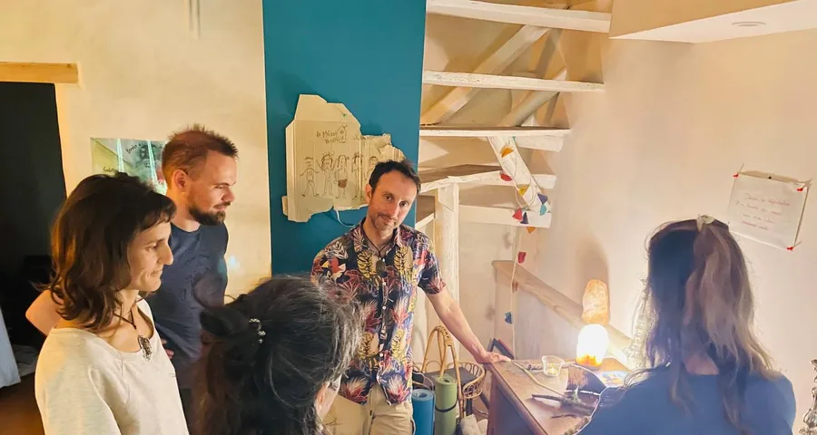 Un groupe rassemblé autour d'un établi, devant des dessins accrochés au mur